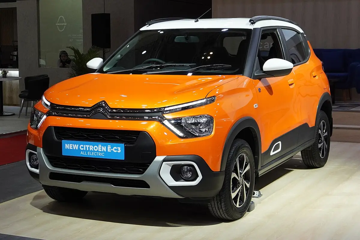 Orange earlier Citroën ë-C3 electric car displayed in Indonesia, seen from the front and side