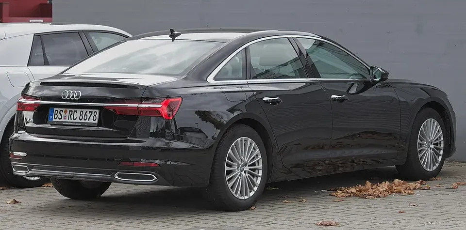 Black Audi A6 C8 sedan viewed from the rear and side