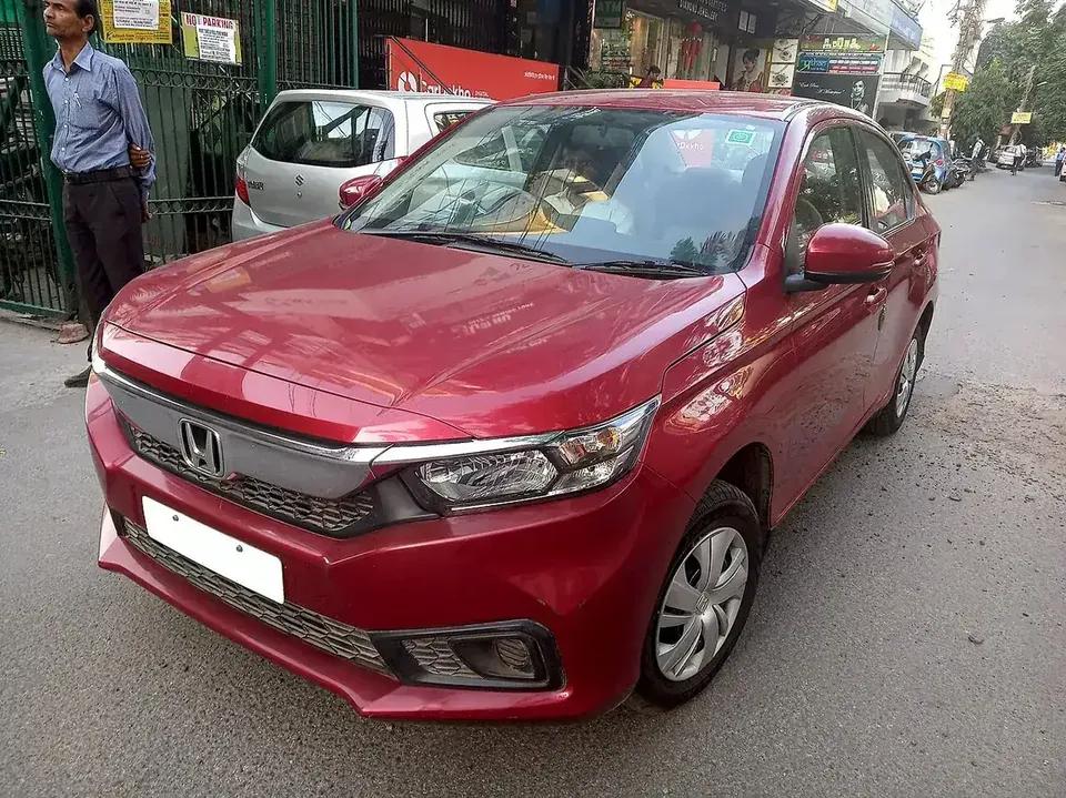Red second-generation Honda Amaze viewed from the front and side in Uttar Pradesh