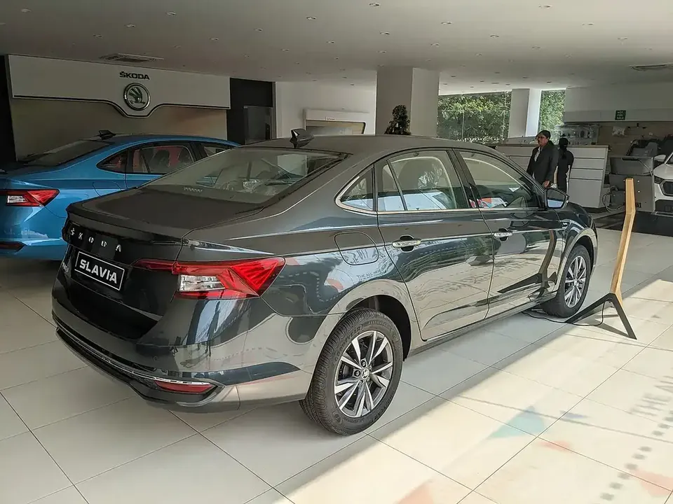 Grey Škoda Slavia viewed from the rear and side in a showroom