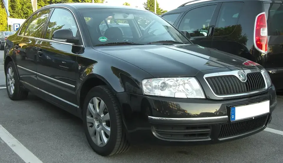 Black first-generation Škoda Superb sedan seen from the front and side