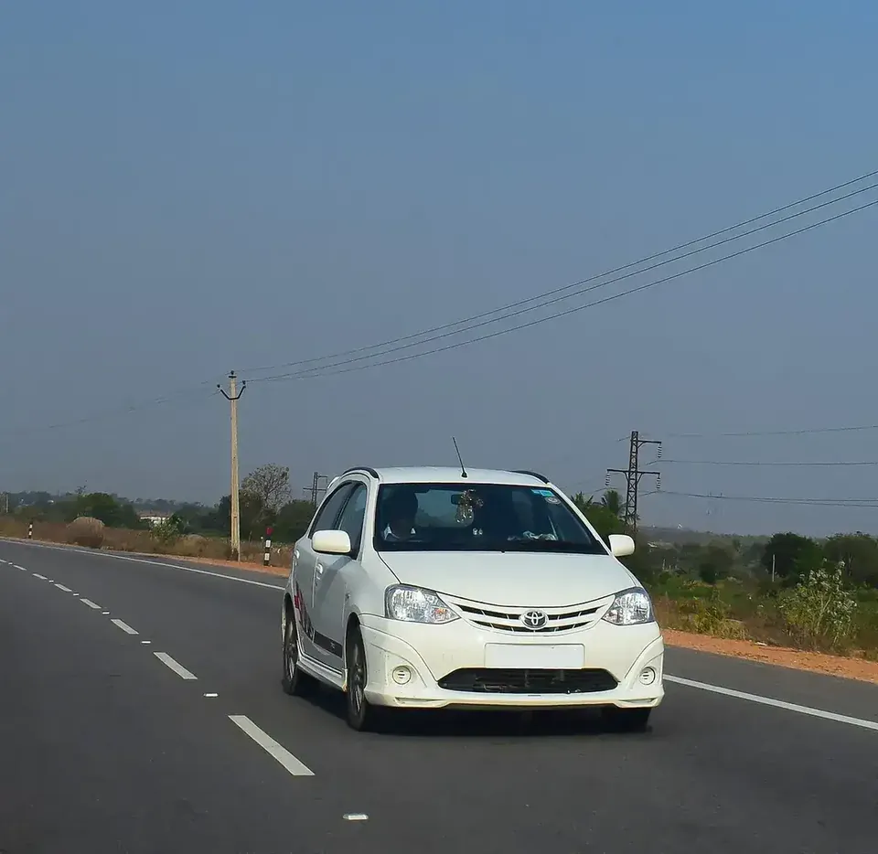 White Toyota Etios Liva hatchback viewed from the front on a road