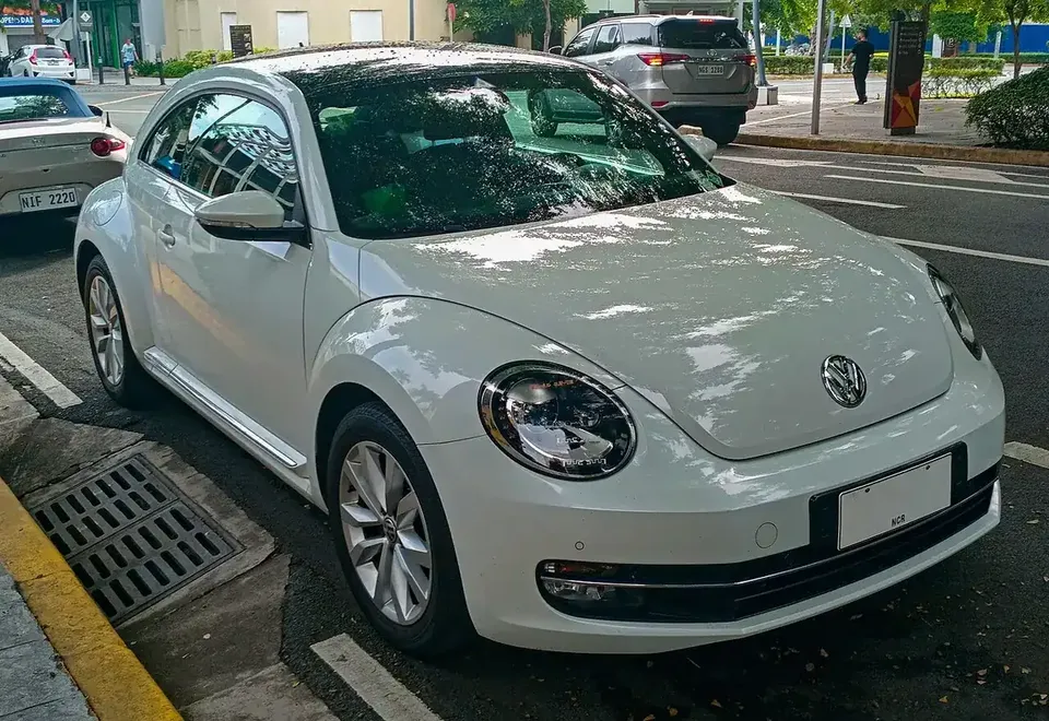 White Volkswagen Beetle A5 coupe viewed from the front and side