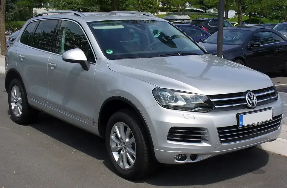 Silver pre-facelift second-generation Volkswagen Touareg viewed from the front and side