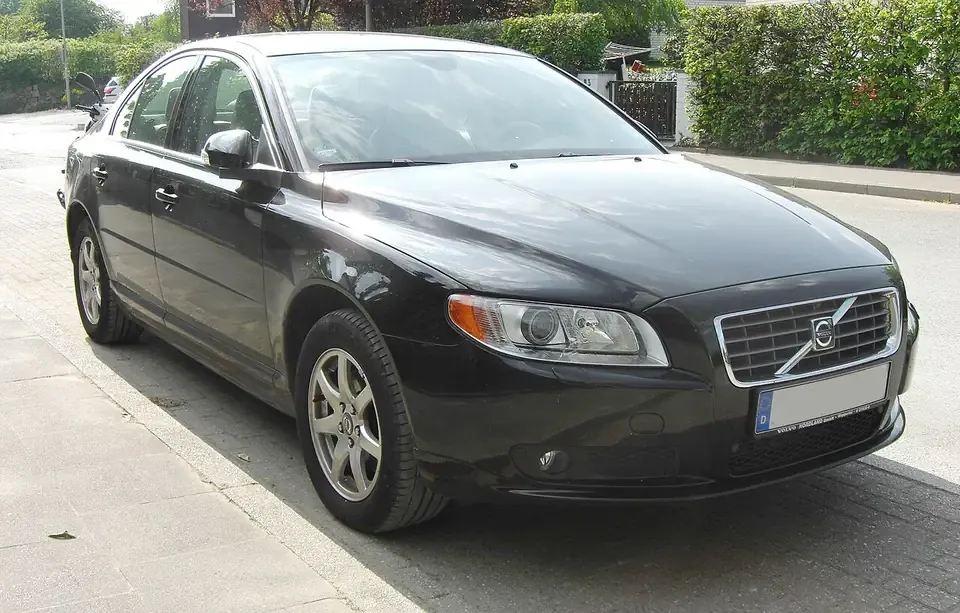 Dark Volvo S80 second-generation sedan seen from the front and side