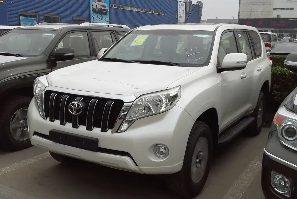 White Toyota Land Cruiser Prado J150 facelift viewed from the front and side
