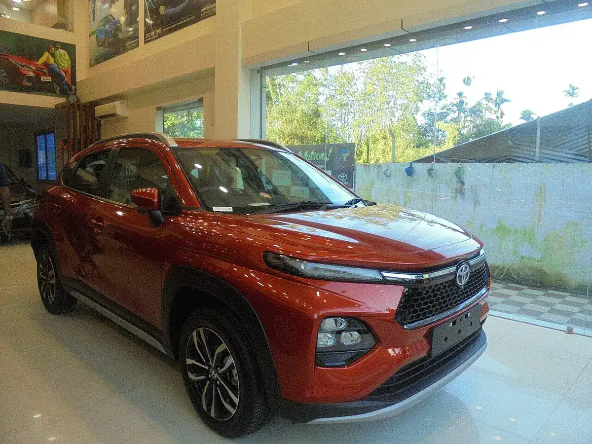 Red Toyota Urban Cruiser Taisor viewed from the front and side in a showroom