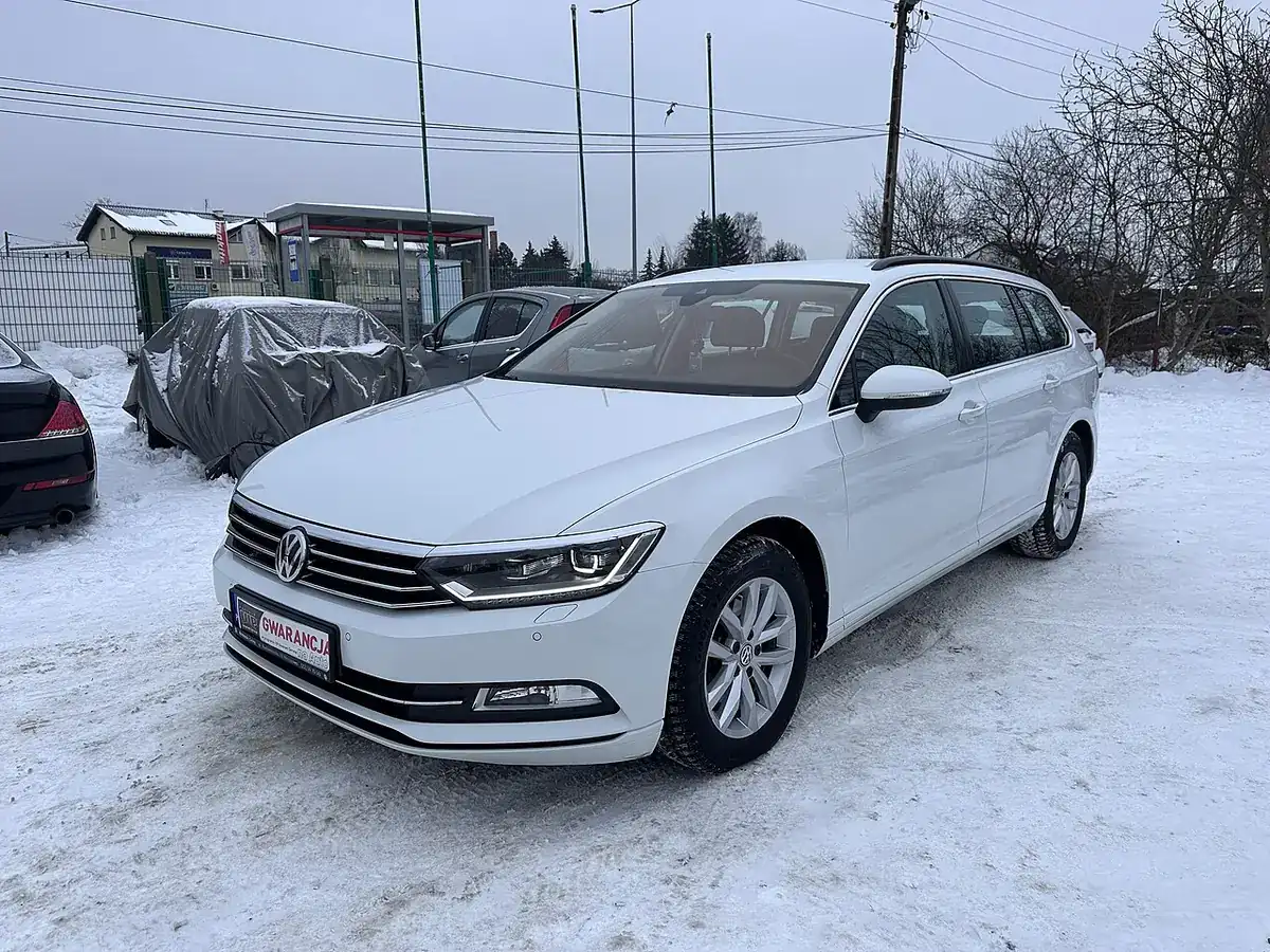 White Volkswagen Passat B8 sedan viewed from the front and side on snow