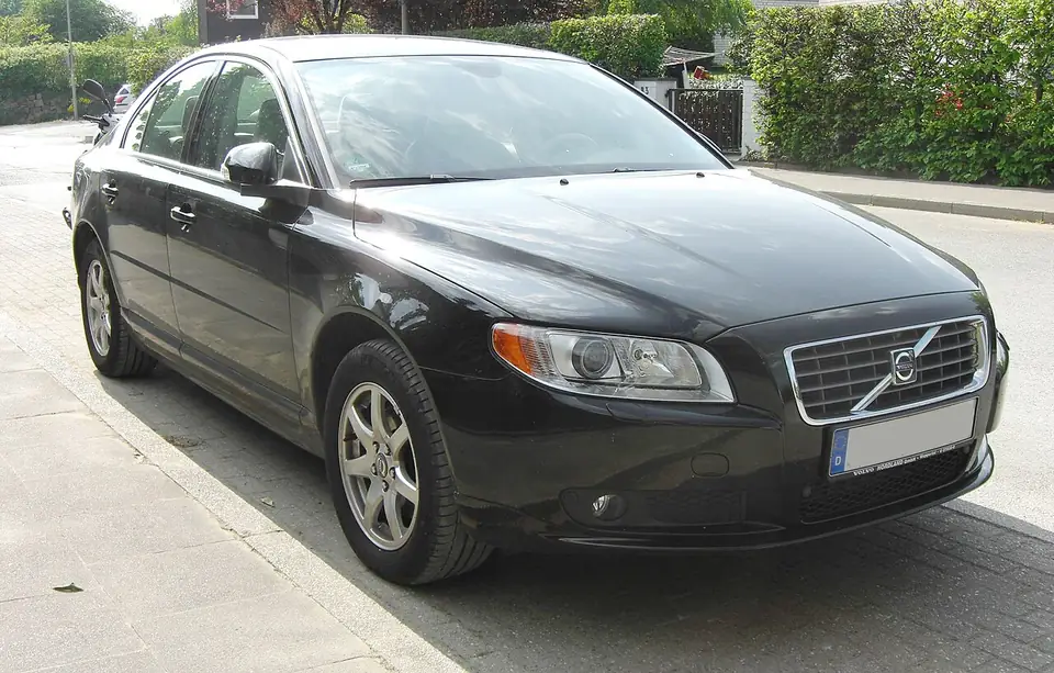 Dark Volvo S80 second-generation sedan seen from the front and side